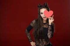 Mooi langharig brunette die een rood hart houden Donkere studio, stock afbeeldingen Mooi langharig brunette die een rood hart houden Donkere studio, stock afbeeldingen