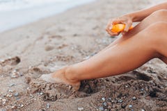 Mooi meisje, de toepassing van de zonroom, op het strand, voeten close-up, kruik geïsoleerde zonroom, stock afbeeldingen Mooi meisje, de toepassing van de zonroom, op het strand, voeten close-up, kruik geïsoleerde zonroom, stock afbeeldingen