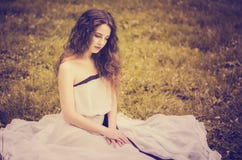 Mooi meisje met luxuriant haar in een lange witte kleding met bedelaars stock foto Mooi meisje met luxuriant haar in een lange witte kleding met bedelaars stock foto