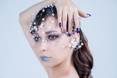 Mooi modelmeisje met het blauwe ontwerp, het gezicht en het haar van de manicurespijker met parels, bergkristallen, decoratie De royalty-vrije stock foto's Mooi modelmeisje met het blauwe ontwerp, het gezicht en het haar van de manicurespijker met parels, bergkristallen, decoratie De royalty-vrije stock foto's