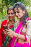 Mooi Nepali-Meisje die foto tonen aan haar moeder in smartphone royalty-vrije stock foto Mooi Nepali-Meisje die foto tonen aan haar moeder in smartphone royalty-vrije stock foto
