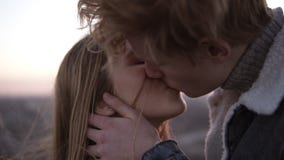 Mooi, romantisch jong paar die zich face to face terwijl status op het dak in wind met een stedelijke achtergrond bevinden Mens stock video Mooi, romantisch jong paar die zich face to face terwijl status op het dak in wind met een stedelijke achtergrond bevinden Mens stock video