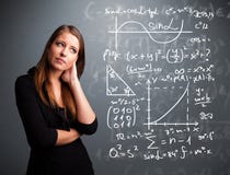 Mooi schoolmeisje die over complexe wiskundige tekens denken royalty-vrije stock foto's Mooi schoolmeisje die over complexe wiskundige tekens denken royalty-vrije stock foto's