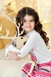 Mooie dichte omhooggaand portraite van krullend meisje met de gouden magische lichten van Kerstmisslingers en boomdecoratie koest Stock Foto's Mooie dichte omhooggaand portraite van krullend meisje met de gouden magische lichten van Kerstmisslingers en boomdecoratie koest Stock Foto's