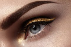 Mooie die macro van vrouwelijk oog met plechtige make-up wordt geschoten Perfecte vorm van wenkbrauwen, eyeliner en vrij gouden l stock foto's Mooie die macro van vrouwelijk oog met plechtige make-up wordt geschoten Perfecte vorm van wenkbrauwen, eyeliner en vrij gouden l stock foto's