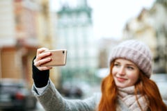 Mooie gembervrouw in de winterkleding die selfie op haar mo nemen royalty-vrije stock afbeeldingen Mooie gembervrouw in de winterkleding die selfie op haar mo nemen royalty-vrije stock afbeeldingen