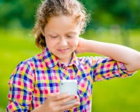 Mooie glimlachende tiener in vrijetijdskleding met smartphone stock fotografie Mooie glimlachende tiener in vrijetijdskleding met smartphone stock fotografie