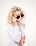Mooie jonge blonde vrouw in donkere glazen en witte sweater Royalty-vrije Stock Afbeeldingen Mooie jonge blonde vrouw in donkere glazen en witte sweater Royalty-vrije Stock Afbeeldingen