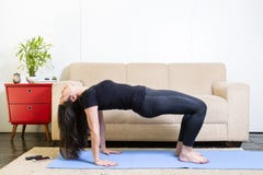 Mooie Kaukasische donkerbruine vrouw in zwarte kleren op blauwe yoga stock afbeeldingen Mooie Kaukasische donkerbruine vrouw in zwarte kleren op blauwe yoga stock afbeeldingen