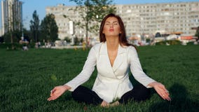 Mooie onderneemster in wit kostuum die yoga voor ontspanning doen openlucht royalty-vrije stock foto Mooie onderneemster in wit kostuum die yoga voor ontspanning doen openlucht royalty-vrije stock foto