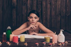 Mooie ontspannen jonge vrouw die in kuuroordsalon leggen met kaarsen a stock fotografie Mooie ontspannen jonge vrouw die in kuuroordsalon leggen met kaarsen a stock fotografie