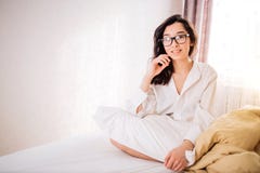 Mooie Positieve vrouwenzitting in bed in ochtend stock foto's Mooie Positieve vrouwenzitting in bed in ochtend stock foto's