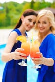Mooie sexy vrouwen in bikini drinken cocktails terwijl het ontspannen in het zwembad stock fotografie Mooie sexy vrouwen in bikini drinken cocktails terwijl het ontspannen in het zwembad stock fotografie