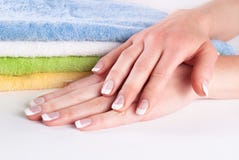 Mooie vrouwenhanden met Franse spijkersmanicure op kleurrijke handdoeken Royalty-vrije Stock Fotografie Mooie vrouwenhanden met Franse spijkersmanicure op kleurrijke handdoeken Royalty-vrije Stock Fotografie