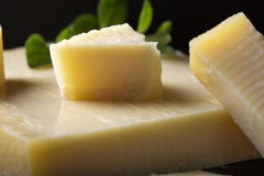 Morceaux de fromage mûri sur l'ardoise foncée avec l'origan vert image libre de droits Morceaux de fromage mûri sur l'ardoise foncée avec l'origan vert image libre de droits