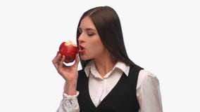Morenita de la muchacha en un traje de negocios en un fondo blanco que come una pera con el sonido metrajes Morenita de la muchacha en un traje de negocios en un fondo blanco que come una pera con el sonido metrajes