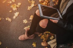 Morenita joven hermosa que se sienta en las hojas de un otoño caidas en un parque, leyendo un eBook en una tableta Imagenes de archivo Morenita joven hermosa que se sienta en las hojas de un otoño caidas en un parque, leyendo un eBook en una tableta Imagenes de archivo