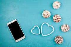 Morgenfrühstück für Valentinsgrußtag Smartphone, Pralinen, zwei dekorative Herzen auf blauem Hintergrund Draufsicht, flache Lage lizenzfreie stockfotos Morgenfrühstück für Valentinsgrußtag Smartphone, Pralinen, zwei dekorative Herzen auf blauem Hintergrund Draufsicht, flache Lage lizenzfreie stockfotos