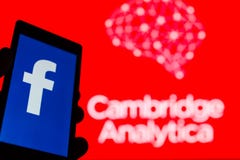 MOSCOW, RUSSIA - MAY 9, 2018: Smartphone in hand with logo of popular social network Facebook. Cambridge Analytica emblem stock images MOSCOW, RUSSIA - MAY 9, 2018: Smartphone in hand with logo of popular social network Facebook. Cambridge Analytica emblem stock images