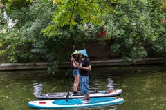 Moscú, parque del verano 5 de julio de 2018: Chica joven y hombre en los sombreros de paja que se colocan en las tablas hawaianas foto de archivo Moscú, parque del verano 5 de julio de 2018: Chica joven y hombre en los sombreros de paja que se colocan en las tablas hawaianas foto de archivo