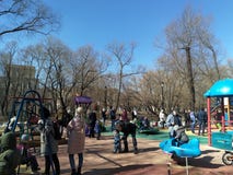 Moskou, 31 rf-Maart: de ouders lopen met hun kinderen op de Speelplaats in het stadspark in de vroege lente royalty-vrije stock foto Moskou, 31 rf-Maart: de ouders lopen met hun kinderen op de Speelplaats in het stadspark in de vroege lente royalty-vrije stock foto