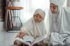 Moslemischer Elternteil- und Tochterlesungsquran stockfotografie Moslemischer Elternteil- und Tochterlesungsquran stockfotografie