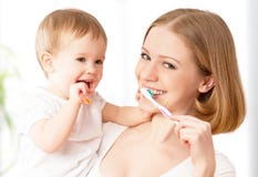Mother and baby girl brushing teeth together stock photos Mother and baby girl brushing teeth together stock photos
