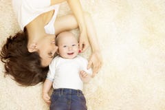 Mother and Baby lying on Carpet, Happy Family Portrait, Kid Boy