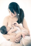 Mother breastfeeding a little baby studio shot