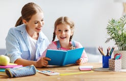 Mother and child daughter doing homework writing and reading at Stock Photo Mother and child daughter doing homework writing and reading at Stock Photo