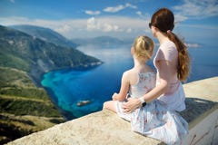Mother and child enjoying the view of picturesque jagged coastline of Kefalonia with clear turquoise waters, surrounded by steep stock photo Mother and child enjoying the view of picturesque jagged coastline of Kefalonia with clear turquoise waters, surrounded by steep stock photo