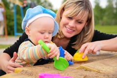 Mother and child play in sandbox