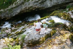 Mother with children sitting by a mountain creek in summer, chilling royalty free stock photos Mother with children sitting by a mountain creek in summer, chilling royalty free stock photos
