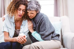 Mother comforting tensed daughter sitting on sofa stock images Mother comforting tensed daughter sitting on sofa stock images