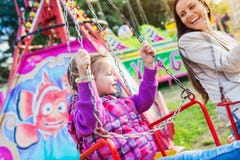 Mother and daughter at fun fair, chain swing ride Royalty Free Stock Photography Mother and daughter at fun fair, chain swing ride Royalty Free Stock Photography