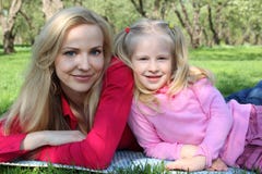 Mother and daughter in park lie on grass Stock Photo Mother and daughter in park lie on grass Stock Photo