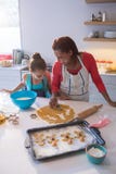 Mother and daughter preparing cookies in kitchen worktop Stock Photography Mother and daughter preparing cookies in kitchen worktop Stock Photography