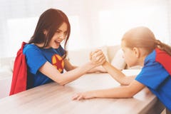 Mother and daughter in suits of superheroes. They compete in arm wrestling royalty free stock photos Mother and daughter in suits of superheroes. They compete in arm wrestling royalty free stock photos