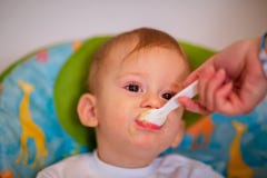 Mother is feeding her baby in the highchair at home royalty free stock image Mother is feeding her baby in the highchair at home royalty free stock image