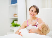 Mother feeding kid in bed Royalty Free Stock Photography Mother feeding kid in bed Royalty Free Stock Photography