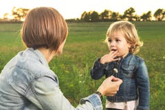 Mother giving a flower to her little daughter in the field stock photography Mother giving a flower to her little daughter in the field stock photography