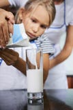 Mother helping daughter to fill glass with milk royalty free stock photo Mother helping daughter to fill glass with milk royalty free stock photo