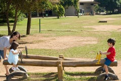 Mother Helping Her Kinds Use A Teeter Totter Stock Photo Mother Helping Her Kinds Use A Teeter Totter Stock Photo