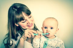 Mother and her baby brushing teeth together - retro style Royalty Free Stock Image Mother and her baby brushing teeth together - retro style Royalty Free Stock Image