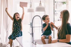 Mother with her children playing in kitchen sink royalty free stock images Mother with her children playing in kitchen sink royalty free stock images
