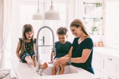 Mother with her children playing in kitchen sink royalty free stock photography Mother with her children playing in kitchen sink royalty free stock photography