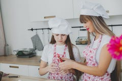 Mother with her daughter are preparing the buns stock photo Mother with her daughter are preparing the buns stock photo