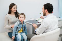 Mother and her son with funny face at the hospital talking to a doctor royalty free stock photo Mother and her son with funny face at the hospital talking to a doctor royalty free stock photo