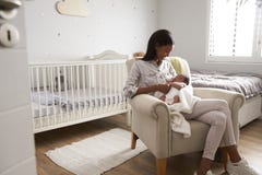 Mother Home from Hospital With Newborn Baby In Nursery stock photography Mother Home from Hospital With Newborn Baby In Nursery stock photography