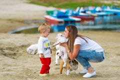 Mother and the little son play with a puppy on the sands at the river stock photos Mother and the little son play with a puppy on the sands at the river stock photos